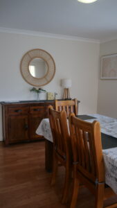 dining table and chairs with buffet and mirror on the wall